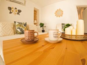 due tazze da caffè su un tavolo di legno in un soggiorno di Stylish Rooftop Retreat with Hot Tub with Loutraki Beach a Loutraki Altre 41 foto