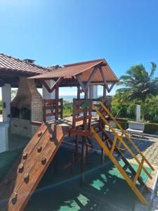 a wooden playground with a pavilion and a slide at Flat Mar doce lar in Conde
