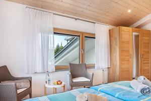 ein Schlafzimmer mit einem Bett und einem Fenster in der Unterkunft Ferienwohnungen Familie Hofer in Argenbühl