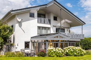 ein großes weißes Haus mit Wintergarten in der Unterkunft Ferienwohnungen Familie Hofer in Argenbühl