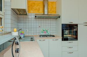 een keuken met witte kasten en een spoelbak bij Mermaid in Cala Gonone