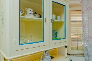 een witte kast met blauwe glazen deuren in een keuken bij Mermaid in Cala Gonone +28 foto's