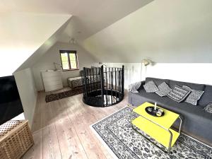 a living room with a gray couch and a yellow table at Genuint hus i Höganäs hamn in Höganäs