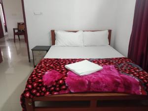 Red Chill Resort في فاغامون: سرير مع بطانية مع