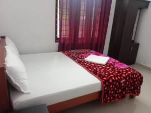 Red Chill Resort في فاغامون: سرير عليه بطانيه حمراء وبيضاء +صورتان