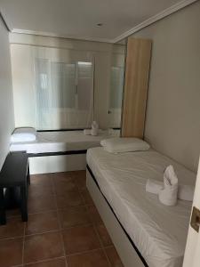 ein Schlafzimmer mit zwei Betten und einem Fenster in der Unterkunft Alojamiento con vistas al mar en Puerto Sagunto in Puerto de Sagunto