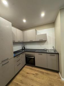 cocina con armarios blancos y suelo de madera en Tiber Domus Fiumicino - Apt 2, en Fiumicino