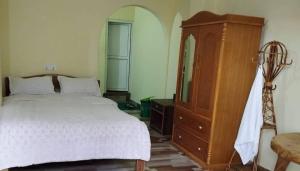 a bedroom with a bed and a wooden dresser at Northern Suite Home in Pokhara