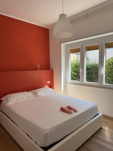 1 dormitorio con 1 cama blanca grande y paredes rojas en Tiber Domus Fiumicino - Apt 2, en Fiumicino