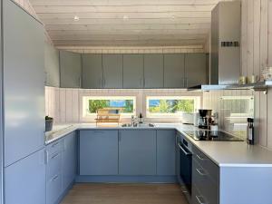 a kitchen with blue cabinets and a counter top at Sea Pearl Lodge in Leknes