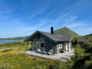 a house on a hill with a view of the ocean at Sea Pearl Lodge in Leknes