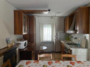 a small kitchen with a table and a microwave at Appartamento con vista sul gruppo dell'Adamello in Malonno