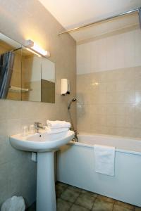 La salle de bains est pourvue d'un lavabo et d'une baignoire. dans l'établissement Hotel Le Lagon, à Rochefort-du-Gard