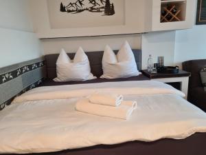 a bed with a pile of towels on it at Feinwald Highline Altenau in Altenau