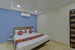a bedroom with a large bed with colorful pillows at FabHotel Rio - Nr Ramoji Filmcity, LB Nagar in Hyderabad