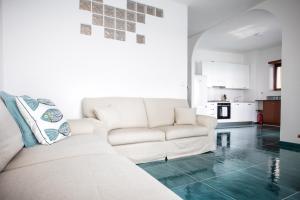 a living room with a white couch and a kitchen at Casa Le Marinelle Amalfi Coast in Vietri sul Mare