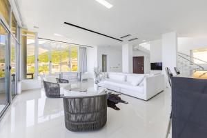 a living room with white furniture and large windows at Villa Belle Azure in Dhërmi