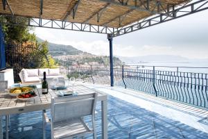 a table and chairs on a balcony with a view of the ocean at Casa Le Marinelle Amalfi Coast in Vietri sul Mare +24 photos