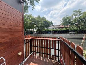 a wooden deck with a fence next to a river at Cozy Canal House 1 min to MRT & Street Foods in Bangkok +50 photos