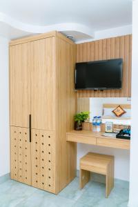 a room with a wooden cabinet with a tv on it at Sea Dragon Hotel Cát Bà & Aparment in Cat Ba