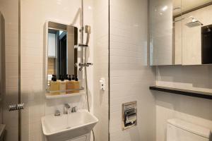 a bathroom with a sink and a toilet and a mirror at Stayfy Paju K-hills in Paju