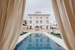a view of a pool with a building in the background at Villa Turco Berti luxury apartments & SPA in Caldiero