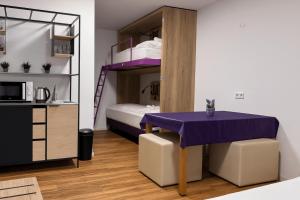 a room with a purple table and a bunk bed at Hotelkonkurrenz Hostel in Nuremberg