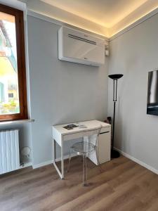 a small white desk in a room with a window at Comfort moderno centro città in Ancona