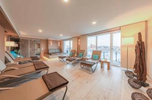 una grande stanza con tavoli, sedie e finestre di Kietz-Idylle - Gemütliche Ferienwohnung mit Balkon und Zugang zu Wellnessbereich a Waren