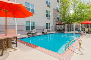 a pool with a table and chairs and an umbrella at TownePlace Suites by Marriott Springfield in Springfield