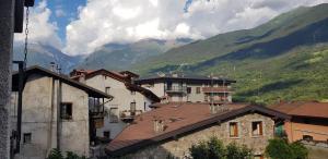 a group of buildings with mountains in the background at Appartamento con vista sul gruppo dell'Adamello in Malonno