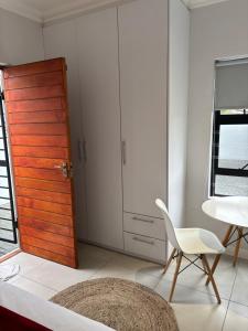a room with a door and a chair and a table at Studio Apartment in Cape Town in Cape Town