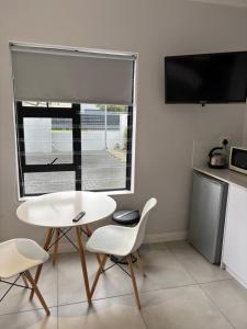 a white table and chairs in a kitchen with a window at Studio Apartment in Cape Town in Cape Town