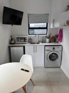 a small kitchen with a sink and a washing machine at Studio Apartment in Cape Town in Cape Town +1 photo