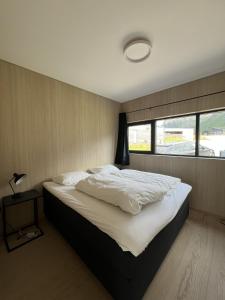 a bedroom with a large white bed with a window at New lodge at seaside, near Henningsvær Lofoten in Kleppstad
