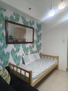 - une chambre avec un lit et un miroir mural dans l'établissement Amigo's Place at Sea Residences, à Manille