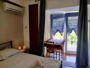 a bedroom with a bed and a table and a window at Small and practical No2 in Límni
