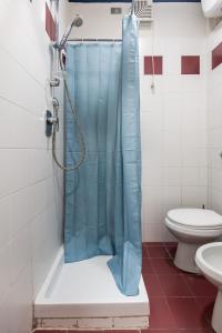 a bathroom with a shower with a blue shower curtain at Griffoni Home in Bologna +15 photos