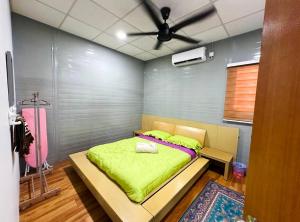 une chambre avec un lit avec une couverture verte dans l'établissement Qudwah Stay,  1 autre photo