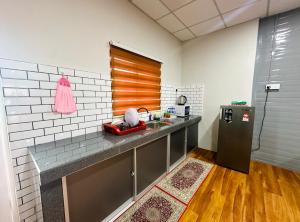 Il comprend une cuisine équipée d'un comptoir et d'un réfrigérateur. dans l'établissement Qudwah Stay, 