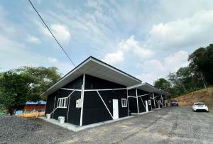 un bâtiment noir avec une voiture garée dans un parking dans l'établissement Qudwah Stay, 