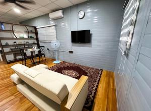 un salon avec un canapé blanc et une télévision dans l'établissement Qudwah Stay, 