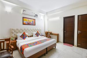 um quarto com uma cama grande em um quarto em FabHotel Comfy Cottage em Gurgaon