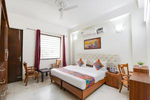 um quarto com uma cama, uma secretária e cadeiras em FabHotel Comfy Cottage em Gurgaon