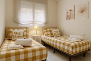 a bedroom with two beds and a window at Alborán Costa del Sol in Estepona