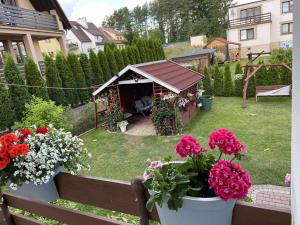 a garden with a gazebo and flowers in a yard at Pokoje u Ani i Zbyszka in Wilkasy