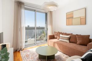 een woonkamer met een bank en een tafel bij Wings Apartment II by An Island Apart in Santa Cruz