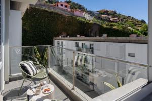 een balkon met een tafel en stoelen op een gebouw bij Wings Apartment II by An Island Apart in Santa Cruz