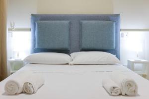 1 cama blanca con 2 almohadas y cabecero azul en Il Centrale, en Nápoles