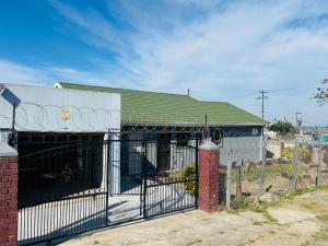 a fence in front of a building with a gate at Konayethu BnB in Mdantsane